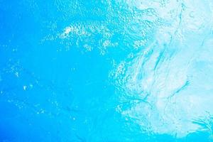 Blurred transparent blue colored clear calm water surface texture with splashes and bubbles. Trendy abstract nature background. Water waves in sunlight. water background photo