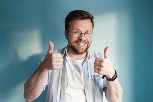 Man showing thumbs up. European smiles and makes an approving gesture with his hands. photo