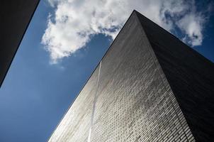 edificio de ladrillo alto de varios pisos contra un cielo y nubes. arquitectura urbana moderna. vista inferior. foto