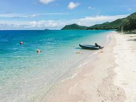 Tropical beach and sea waves with speed boat and island background. Thailand photo