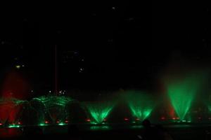 fountain or water dance show at night with colorful light with black background photo