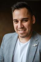 portrait of the groom in a light gray suit photo