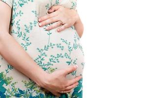 Belly of a pregnant girl in dress. Isolated photo