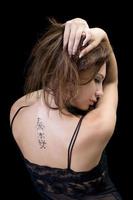 Tattoo on a back of the young woman photo