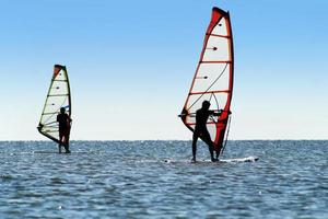 Silhouette of a two windsurfers photo