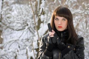 Portrait of young woman with a pistol photo