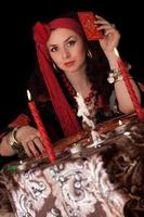Gypsy woman sitting with cards. Isolated photo
