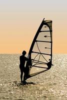 Silhouette of a windsurfer on waves of a gulf photo