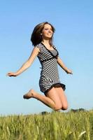 pretty girl jumping in field photo