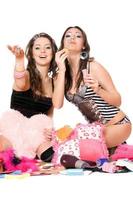 Two cheerful girls blow bubbles. Isolated photo