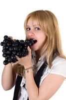 retrato de la niña comiendo uvas. aislado foto