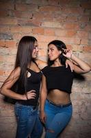 Two brunettes wearing black t-shirts and jeans photo