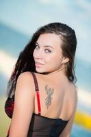 Portrait of smiling young brunette with tattoo photo