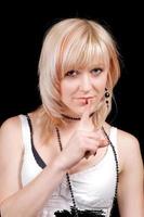 The young blonde with a finger at lips. Isolated photo