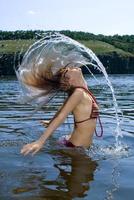 The beauty young woman bathes in the river photo