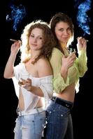 Two smiling pretty girlfriends with a cigars photo