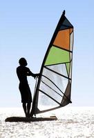Silhouette of a windsurfer on waves of a bay photo