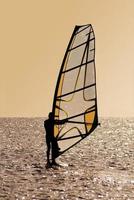 Silhouette of a windsurfer on waves photo