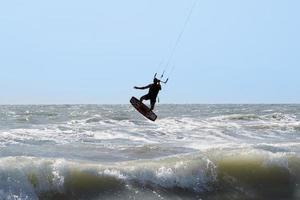 silueta de kite surf, saltando y volando foto