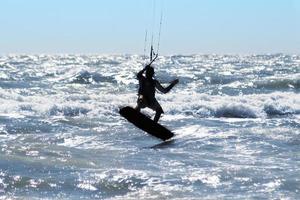 Silhouette of kite surfer photo