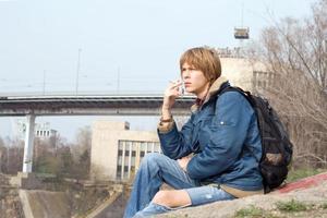 el tipo sentado con un cigarrillo al aire libre 1 foto
