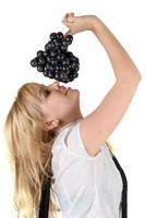 Portrait of the smiling girl with grapes cluster. Isolated photo