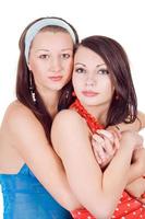 Two embracing beauty young women. Isolated on a white photo