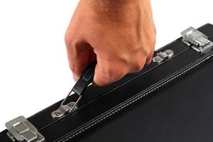 Hand with a black suitcase. Isolated on white background photo