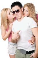 Two attractive blonde kissing young man photo