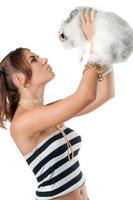 Pretty young woman playing with rabbit photo