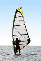 Silhouette of a windsurfer on waves of a sea photo