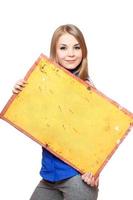 Smiling young woman posing with yellow vintage board photo