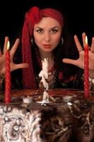 Witch at the table with candles. Isolated photo