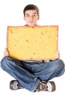 Surprised young man holding yellow board photo