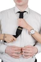 Young man, a tie and female hands. Isolated on white photo