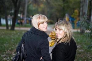 Portrait of the two young women in autumn park photo