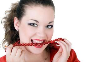 Young beautiful woman with a beads in a teeth photo