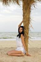 Young brunette on the palm tree photo