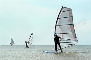 siluetas de tres windsurfistas foto