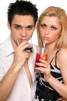 Pretty young couple with cocktails. Isolated photo