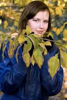 smiling girl amongst the autumn leaves photo