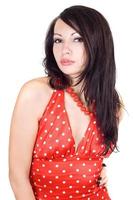 The young beautiful brunette in a red dress. Isolated photo