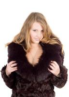 The young beautiful woman in a fur coat over white photo