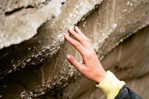 Hand touch close up prehistorical artifacts-shell fossils in stone in Pantishara - Datvis khevi valley in Vashlovani national park photo