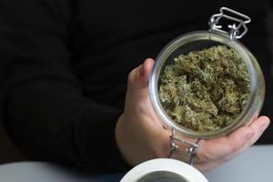 Glass jar full of cannabis buds ready to smoke. Marijuana smoking industry business photo