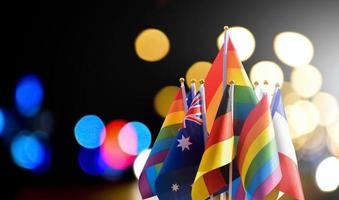 Rainbow flags with Franch, Germany and Australia flags with bokeh street light background, concept for LGBT celebrations around the world. photo