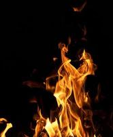 fuego ardiente con troncos humeantes en una noche oscura foto