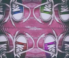 Old youth colored sneakers on old pink wooden surface, top view photo