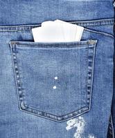 paper cards in the back pocket of blue jeans photo