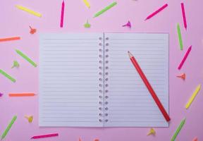 notebook in line and red wooden pencil photo